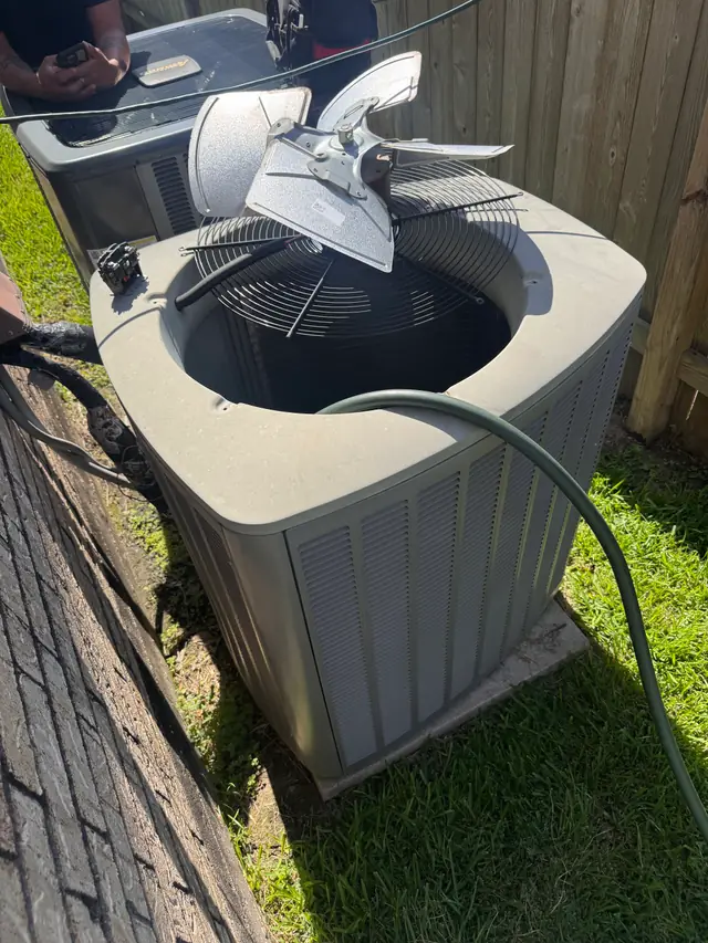 Condenser fan assembly lifted clear of the unit for a coil clean